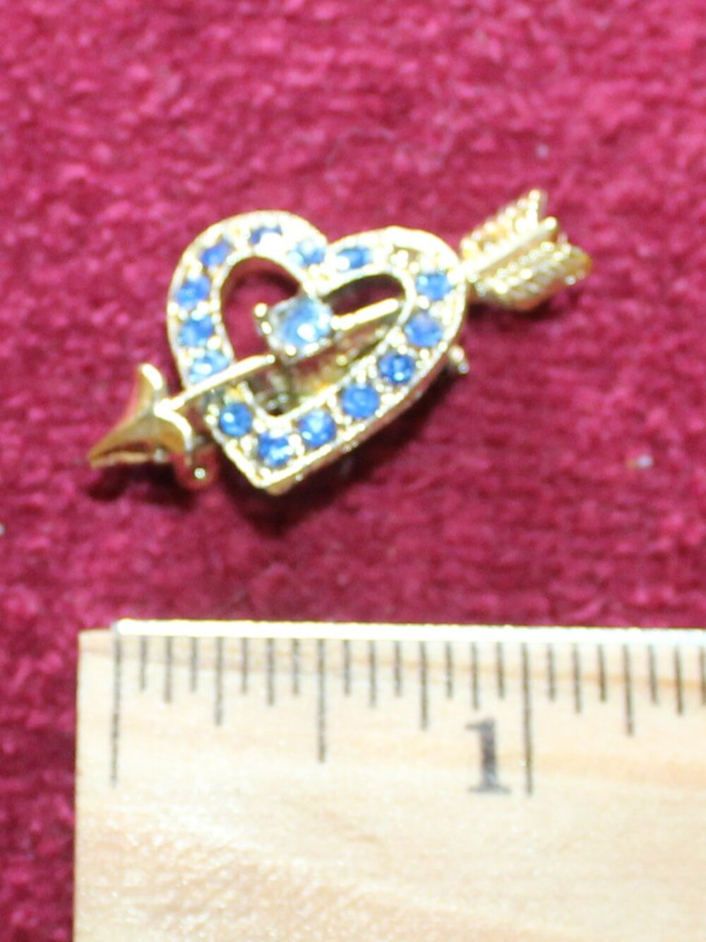 Vintage gold-tone heart-and-arrow brooch accented with sparkling blue rhinestone